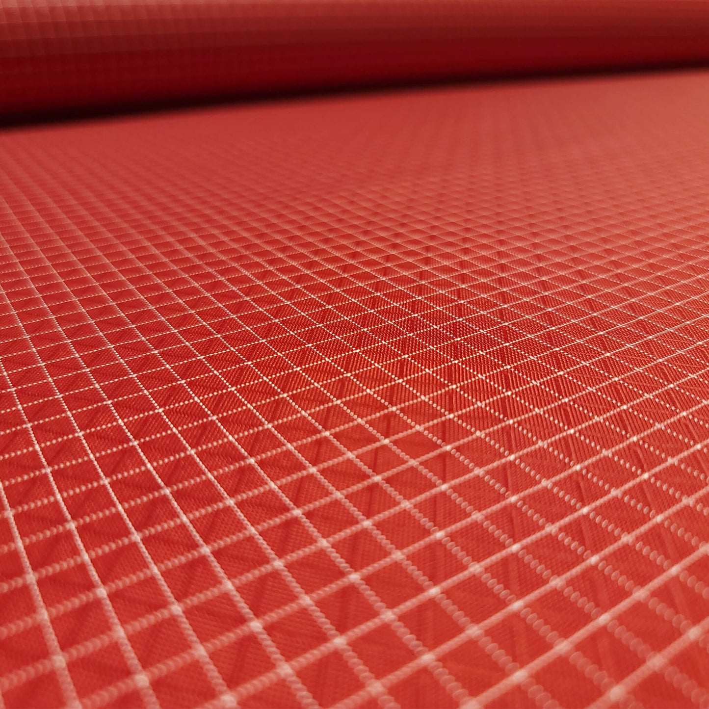 High-quality image showcasing my Brick Red 210D UHMWPE Gridstop Nylon fabric, emphasizing its lightweight, durable woven texture and unique waterproof properties. The image highlights the fabric's intricate UHMWPE fiber grid, its robust 210D denier thickness, and the dual protective coating – 1000mm PU on the back and DWR on the front. Ideal for visualizing the fabric's application in making resilient, weather-resistant outdoor gear like backpacks, fanny packs, and reinforcement areas.