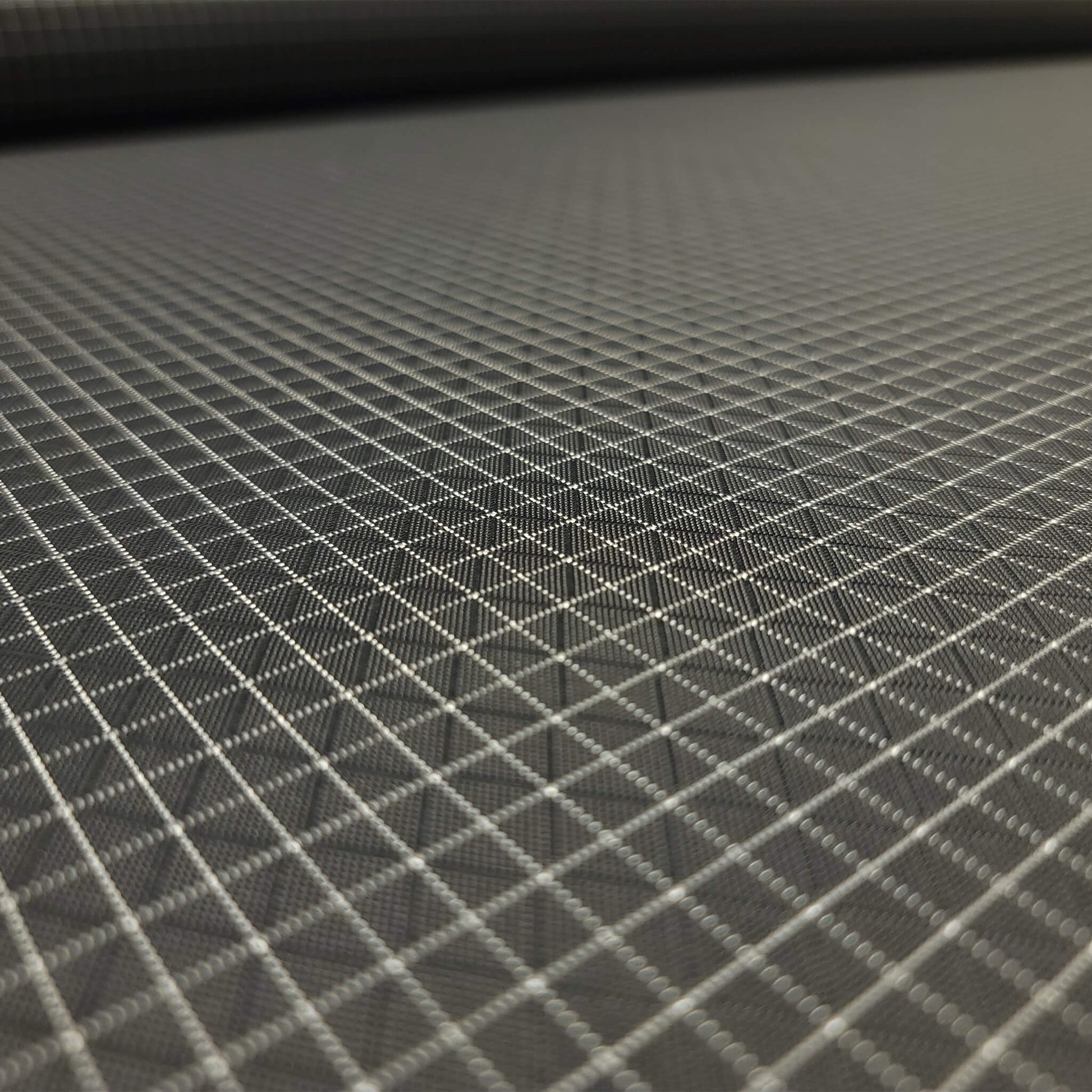 High-quality image showcasing my Charcoal Grey 210D UHMWPE Gridstop Nylon fabric, emphasizing its lightweight, durable woven texture and unique waterproof properties. The image highlights the fabric's intricate UHMWPE fiber grid, its robust 210D denier thickness, and the dual protective coating – 1000mm PU on the back and DWR on the front. Ideal for visualizing the fabric's application in making resilient, weather-resistant outdoor gear like backpacks, fanny packs, and reinforcement areas.