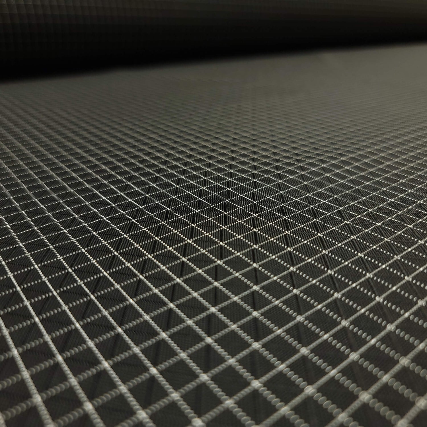 High-quality image showcasing my Eerie Black 210D UHMWPE Gridstop Nylon fabric, emphasizing its lightweight, durable woven texture and unique waterproof properties. The image highlights the fabric's intricate UHMWPE fiber grid, its robust 210D denier thickness, and the dual protective coating – 1000mm PU on the back and DWR on the front. Ideal for visualizing the fabric's application in making resilient, weather-resistant outdoor gear like backpacks, fanny packs, and reinforcement areas.