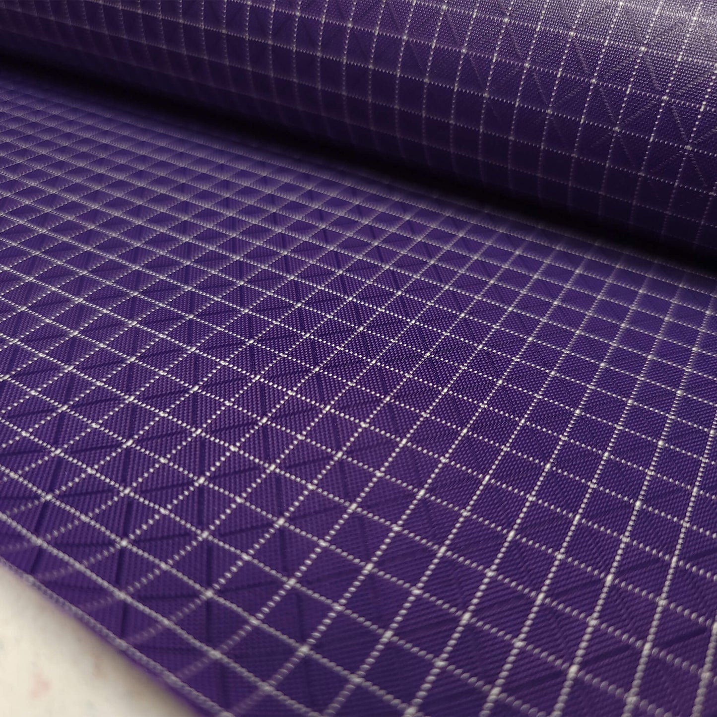 High-quality image showcasing my Grape Purple 210D UHMWPE Gridstop Nylon fabric, emphasizing its lightweight, durable woven texture and unique waterproof properties. The image highlights the fabric's intricate UHMWPE fiber grid, its robust 210D denier thickness, and the dual protective coating – 1000mm PU on the back and DWR on the front. Ideal for visualizing the fabric's application in making resilient, weather-resistant outdoor gear like backpacks, fanny packs, and reinforcement areas.