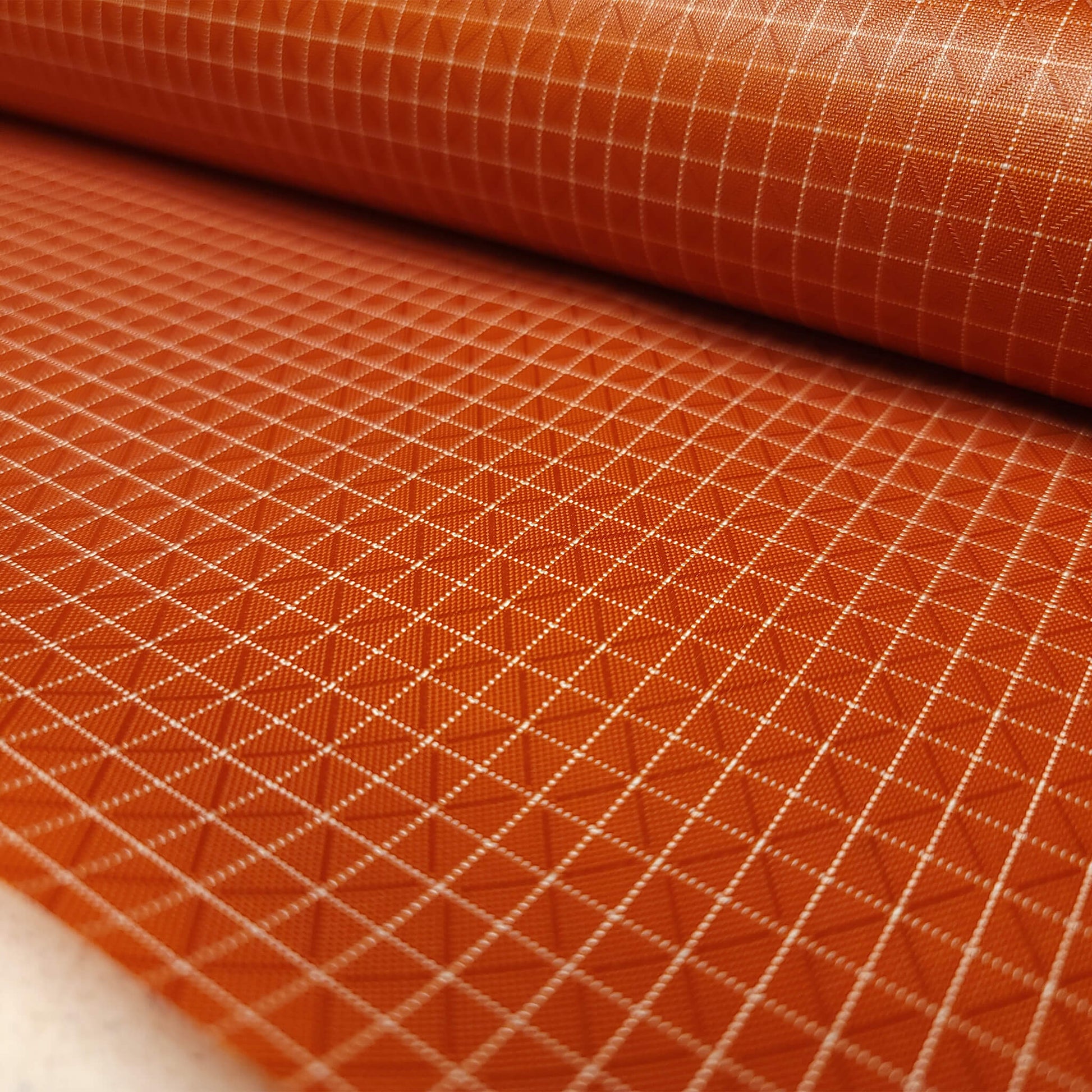 High-quality image showcasing my Mars Orange 210D UHMWPE Gridstop Nylon fabric, emphasizing its lightweight, durable woven texture and unique waterproof properties. The image highlights the fabric's intricate UHMWPE fiber grid, its robust 210D denier thickness, and the dual protective coating – 1000mm PU on the back and DWR on the front. Ideal for visualizing the fabric's application in making resilient, weather-resistant outdoor gear like backpacks, fanny packs, and reinforcement areas.