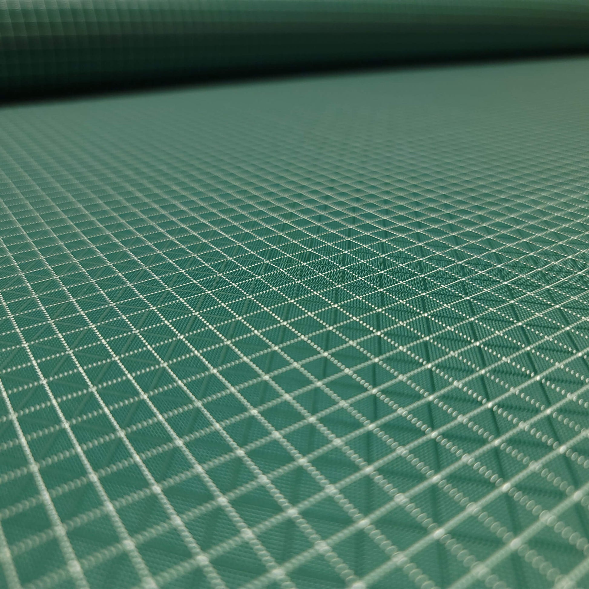 High-quality image showcasing my Pine Green 210D UHMWPE Gridstop Nylon fabric, emphasizing its lightweight, durable woven texture and unique waterproof properties. The image highlights the fabric's intricate UHMWPE fiber grid, its robust 210D denier thickness, and the dual protective coating – 1000mm PU on the back and DWR on the front. Ideal for visualizing the fabric's application in making resilient, weather-resistant outdoor gear like backpacks, fanny packs, and reinforcement areas.