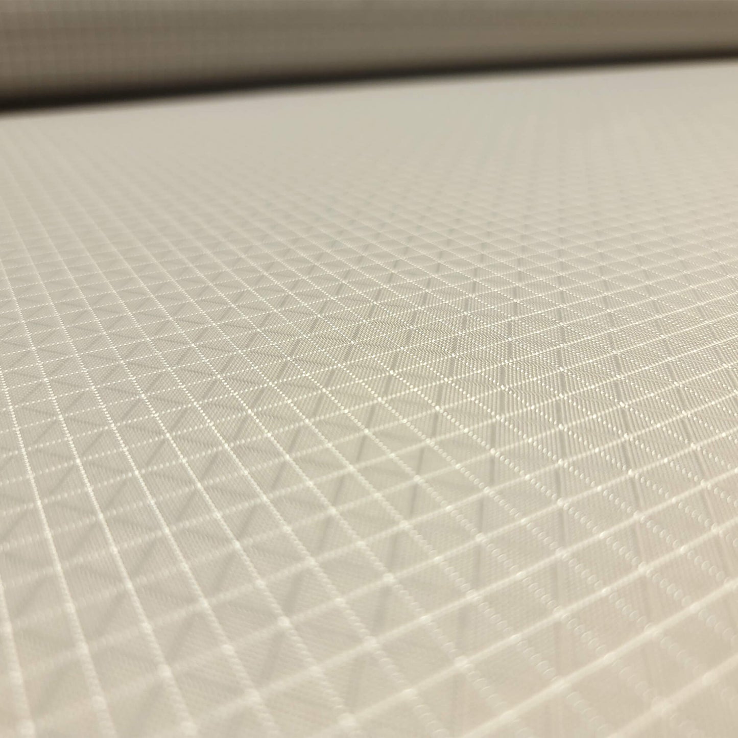 High-quality image showcasing my Stone Grey 210D UHMWPE Gridstop Nylon fabric, emphasizing its lightweight, durable woven texture and unique waterproof properties. The image highlights the fabric's intricate UHMWPE fiber grid, its robust 210D denier thickness, and the dual protective coating – 1000mm PU on the back and DWR on the front. Ideal for visualizing the fabric's application in making resilient, weather-resistant outdoor gear like backpacks, fanny packs, and reinforcement areas.