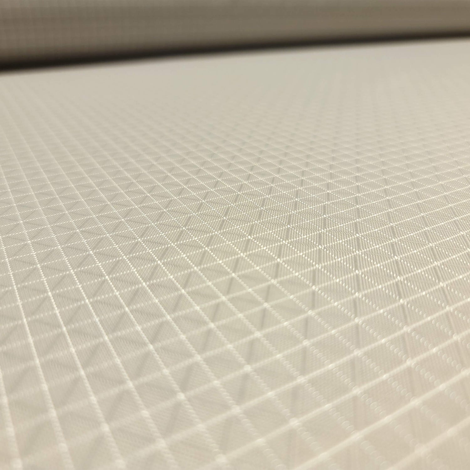 High-quality image showcasing my Stone Grey 210D UHMWPE Gridstop Nylon fabric, emphasizing its lightweight, durable woven texture and unique waterproof properties. The image highlights the fabric's intricate UHMWPE fiber grid, its robust 210D denier thickness, and the dual protective coating – 1000mm PU on the back and DWR on the front. Ideal for visualizing the fabric's application in making resilient, weather-resistant outdoor gear like backpacks, fanny packs, and reinforcement areas.