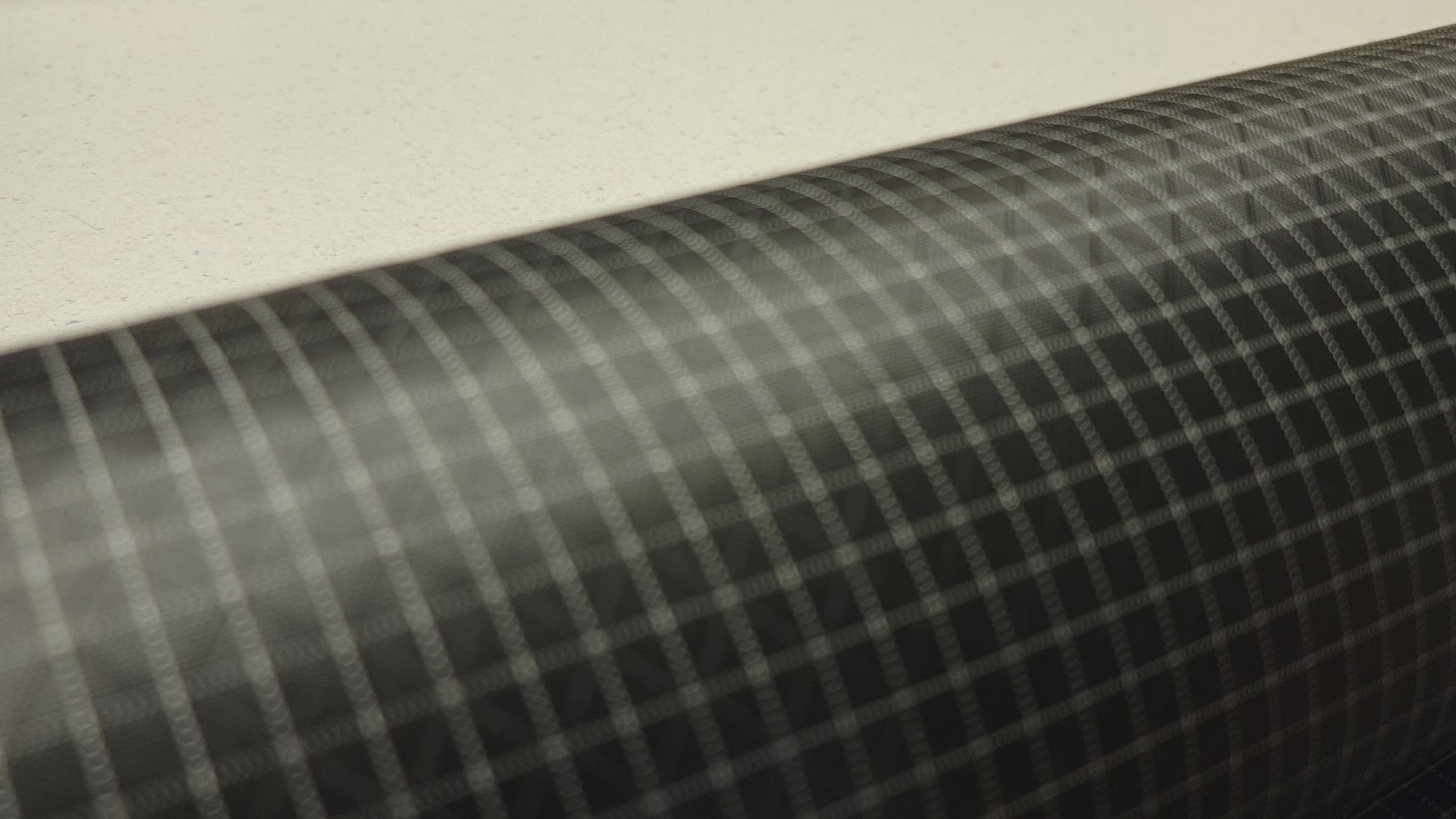 High-quality video showcasing Eerie Black 210D UHMWPE Gridstop Nylon fabric, emphasizing its lightweight, durable woven texture and unique waterproof properties. The video highlights the fabric's intricate UHMWPE fiber grid, its robust 210D denier thickness, and the dual protective coating – 1000mm PU on the back and DWR on the front. Ideal for visualizing the fabric's application in making resilient, weather-resistant outdoor gear like backpacks, fanny packs, and reinforcement areas.